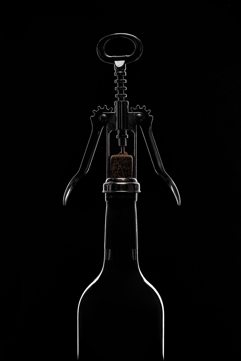 бутылка вина с открывалкой на чёрном фоне