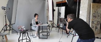 фотограф снимает деловой портрет женщины в студии