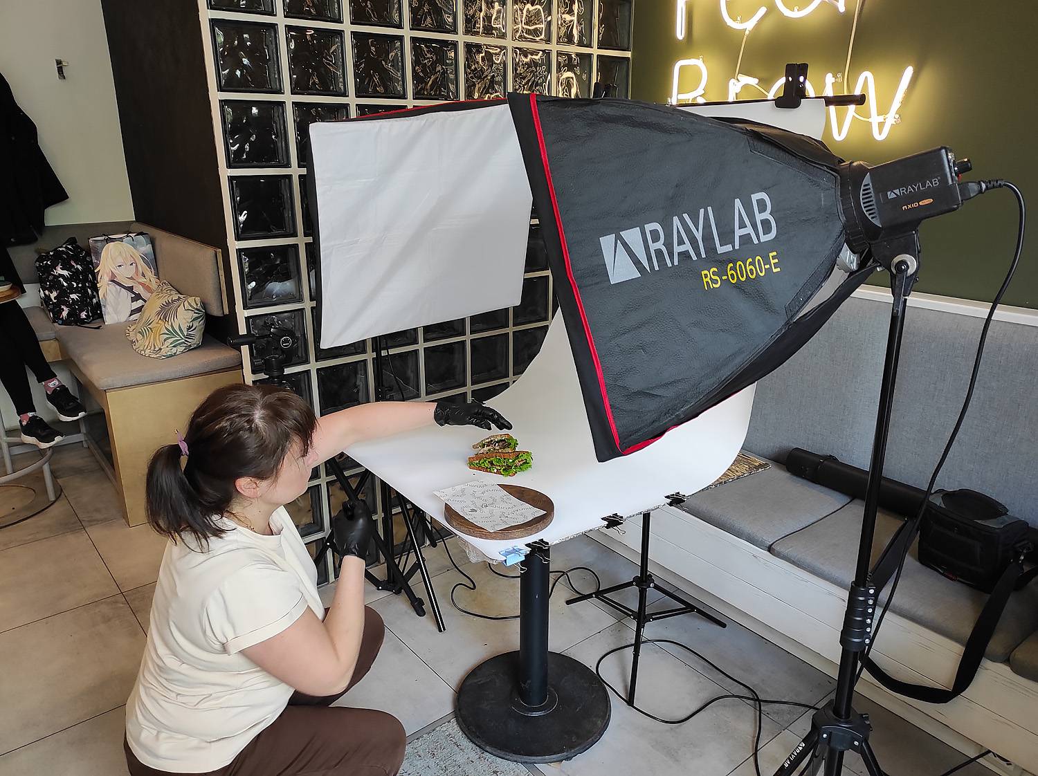 фуд-стилист делает раскладку блюда для фотосъёмки в кафе